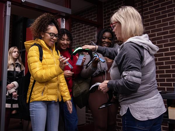 Students smile as they are welcomed to the first day of second semester by security.