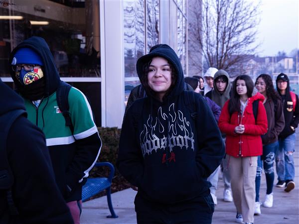 Student bundle themselves for the freezing journey from their bus to school on the first day classes resume.